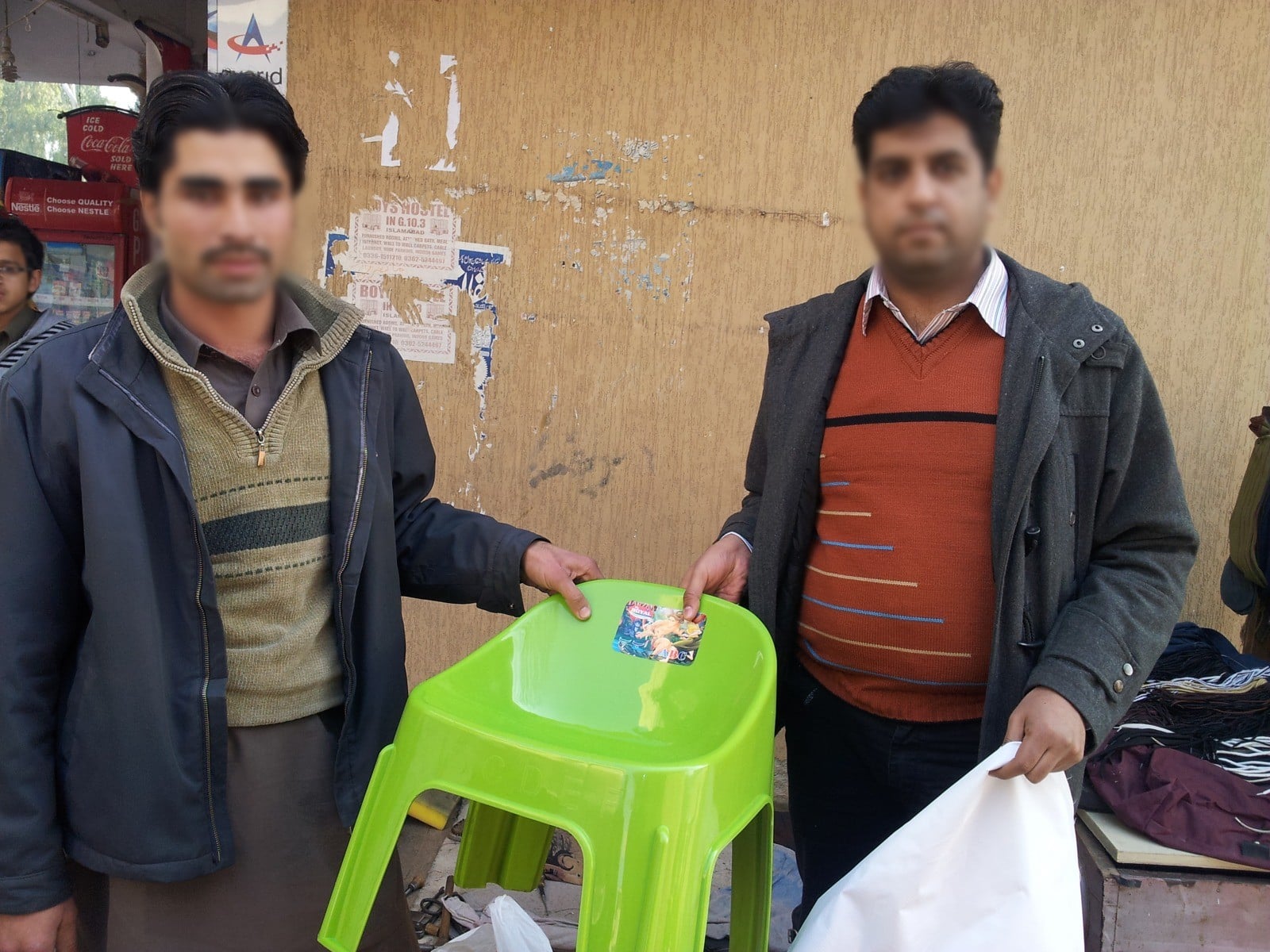 A street cobbler and a Peace Through Prosperity team member at his stall, Islamabad, 2013. Faces blurred.